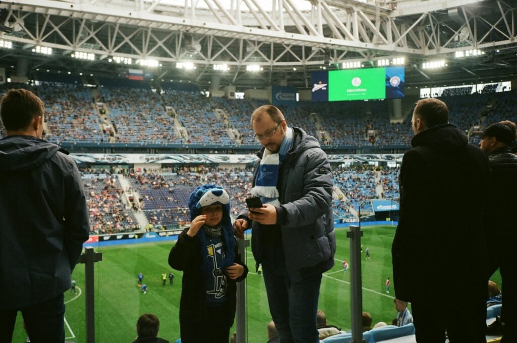 Pai e filho tirando uma foto em um jogo de futebol