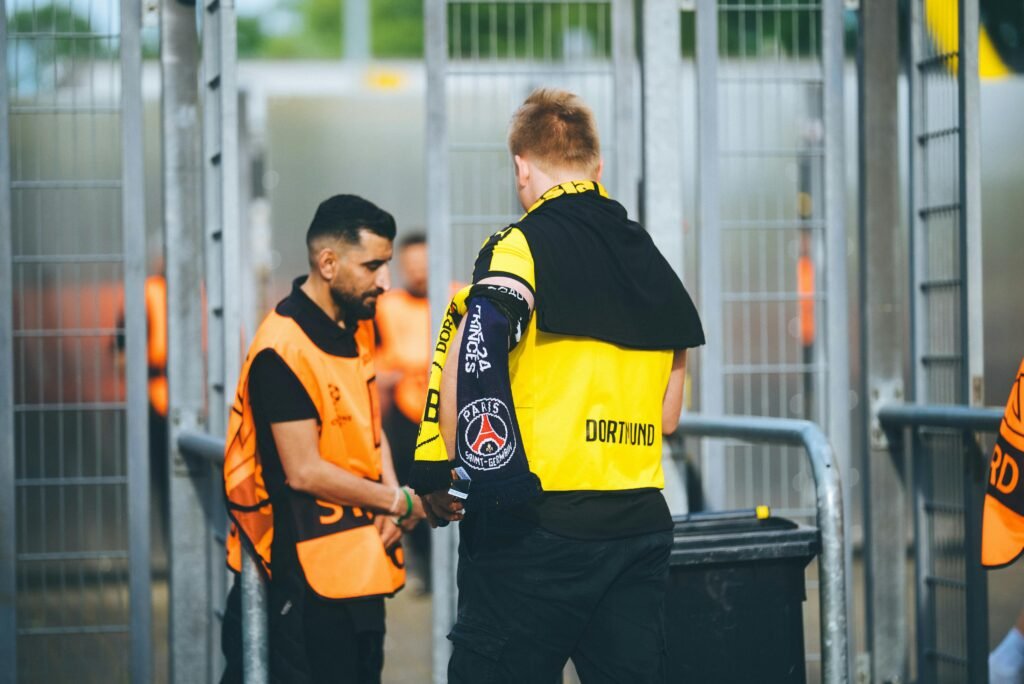 Torcedor de futebol mostrando o ingresso na entrada do estádio